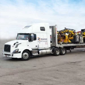 Heavy machinery loaded on ET Motor Freight flatbed.
